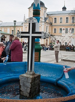 Le persone che stanno per prendere l'acqua santa che versa dalla croce - Guida a Mosca